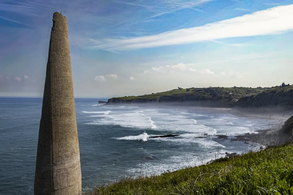 Chimenea de ladrillo asomada al mar sobre la costa